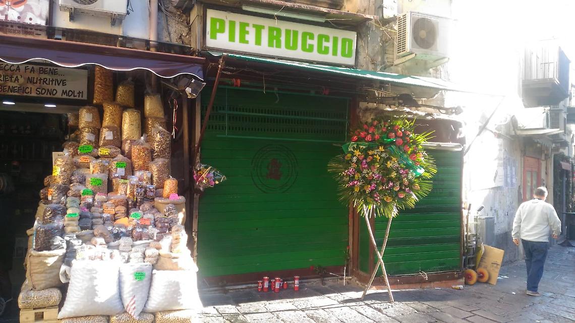 Morto per infarto durante rapina: fiori e lumini davanti negozio